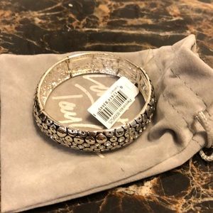 A silver bracelet on a stretch band